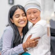 Radiotherapy centre - woman with cancer embracing adult