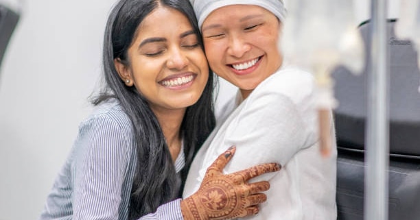 Radiotherapy centre - woman with cancer embracing adult