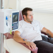 chemotherapy - IV drip attached to young male patient's hand during chemotherapy