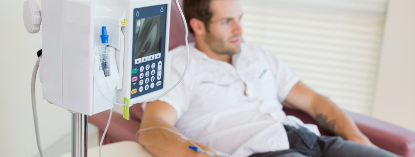 chemotherapy - IV drip attached to young male patient's hand during chemotherapy